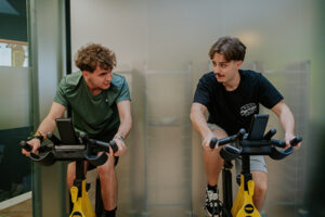 Dos chicos en la bici estática mirándose entre ellos